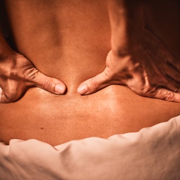 Close-up of a massage therapist's hands during a spa package service.