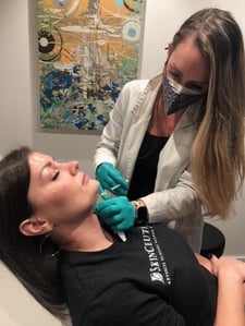 Nurse practitioner injecting a patient with Kybella under her chin at Viva Day Spa + Med Spa.