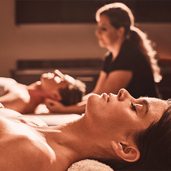 Man and woman receiving a couples massage at Viva Day Spa in Austin, TX.