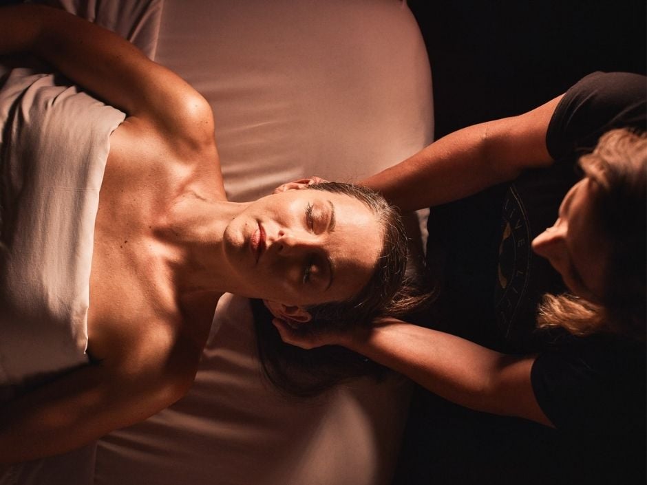 Woman lying on her back face-up receiving a upper shoulder massage from a massage therapist at Viva Day Spa + Med Spa.