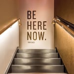 Sign at Viva Day Spa + Med Spa in Austin, Texas with a quote from Ram Dass that reads "Be Here Now."