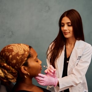 Seema Singh, FNP-C, Aesthetic Nurse Practitioner & Injection Specialist at Viva Day Spa + Med Spa in Austin, Dallas, and Round Rock, Texas performing a lip filler treatment to enhance lip volume, shape, and contour.