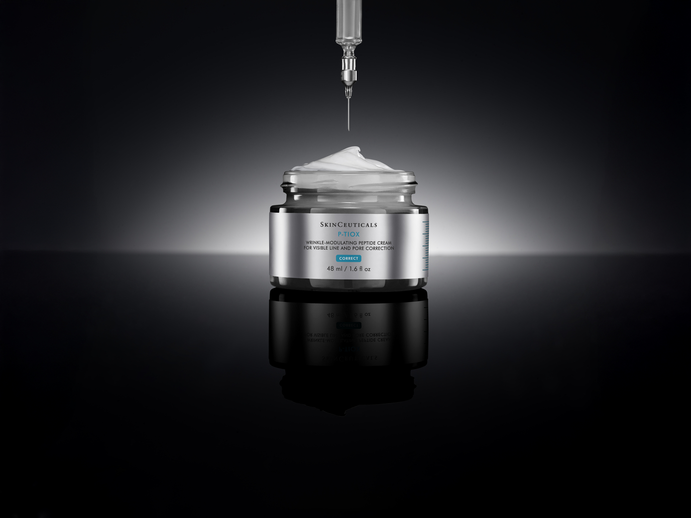 SkinCeuticals P-TIOX Wrinkle-Modulating Peptide Cream open jar with a syringe hovering above it, representing the cream's neurotoxin-inspired peptide formula, on a dark reflective surface