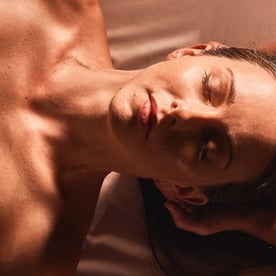 A woman with dewy, glowing skin relaxes with her eyes closed at Viva Day Spa.
