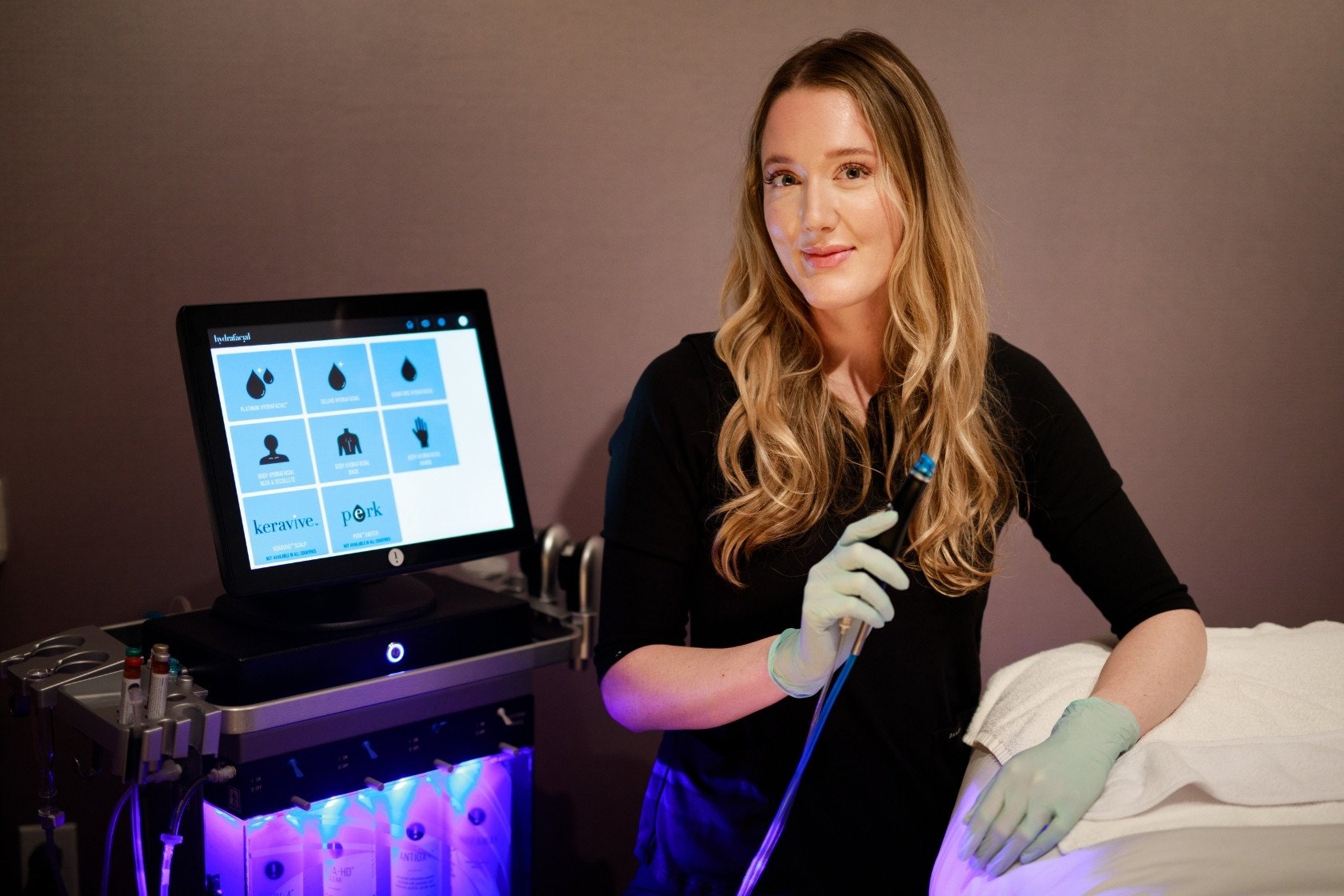 Licensed esthetician with Hydrafacial wand and machine ready for treatment at Viva Day Spa + Med Spa | Austin, Dallas, Round Rock