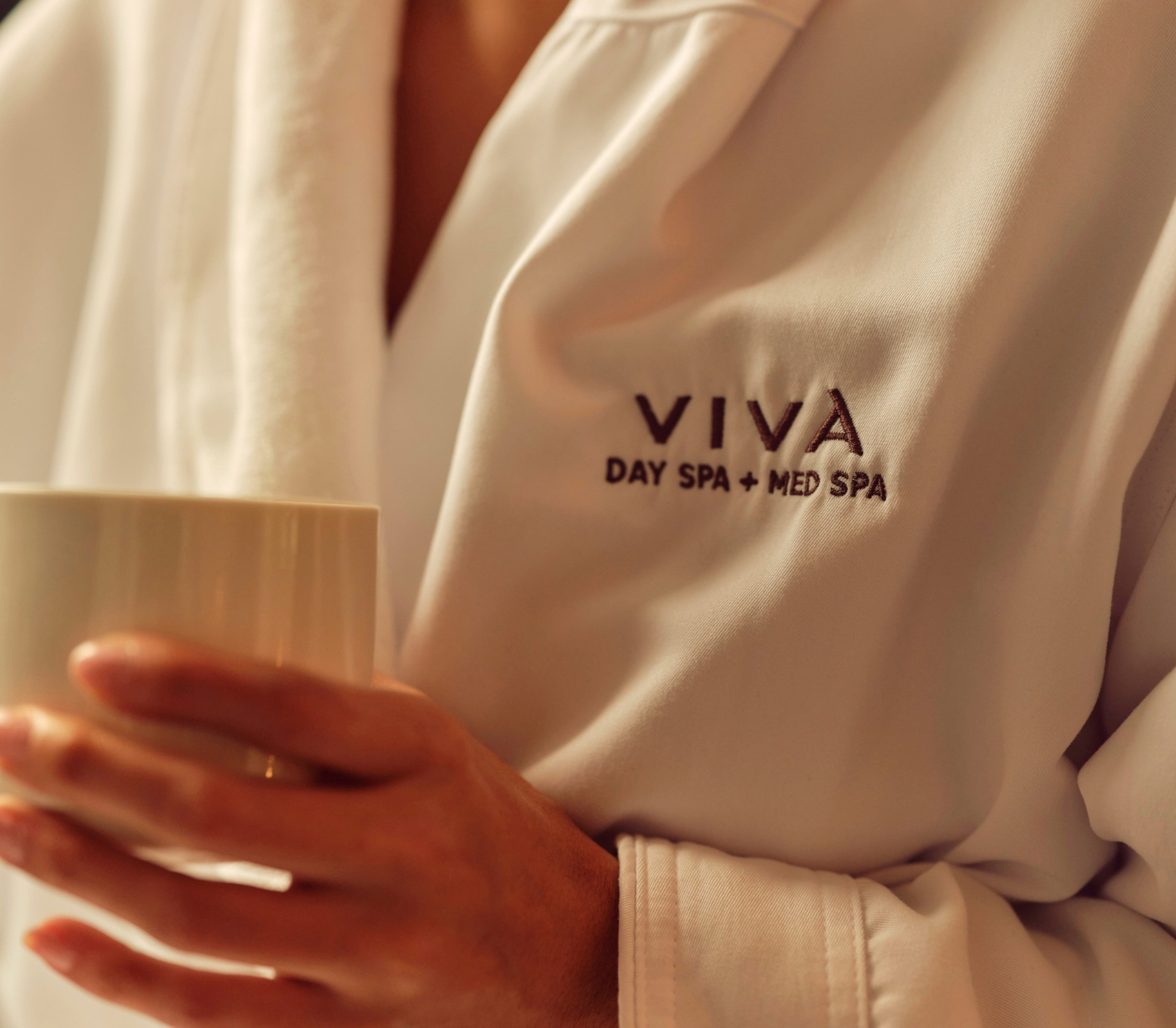 Viva Day Spa + Med Spa Member in a Robe Holding Tea