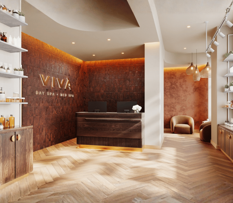 The lobby at Viva Day Spa + Med Spa Morningside in Atlanta, GA, welcomes guests with warm wood finishes, a gold-framed glass door, and professional skin care product displays.