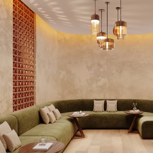 Peaceful relaxation lounge at Viva Day Spa + Med Spa Morningside in Atlanta, GA, with curved green seating, plush pillows, and amber pendant lights.